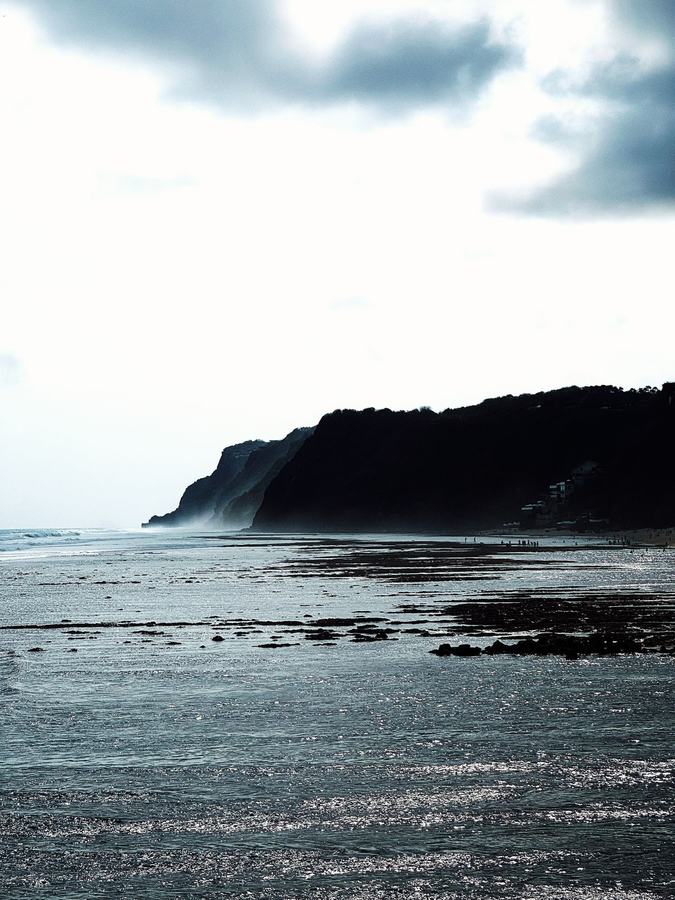 Côte rocheuse à marée basse sous un ciel nuageux