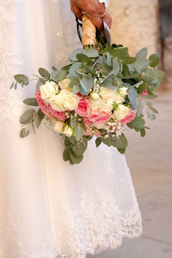 Bouquet de roses et d'eucalyptus tenu par la mariée