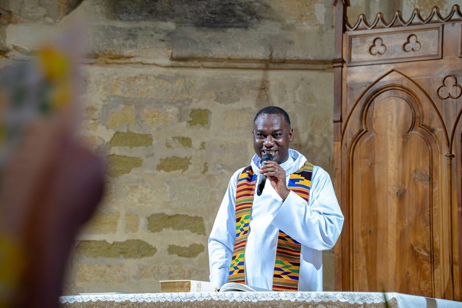 Prêtre souriant prenant la parole pendant la messe