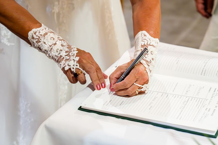 Mariée signant le registre, mitaines en dentelle