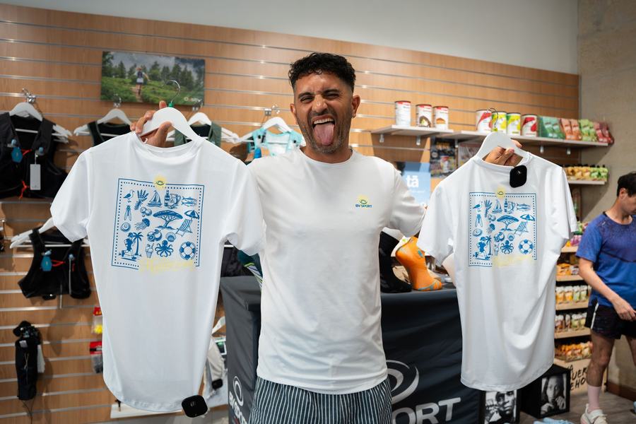 Coureur posant avec les t-shirts de la sortie dans le magasin Running Conseil