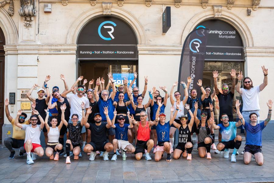 Groupe de coureurs Running Conseil bras levés devant le magasin à Montpellier