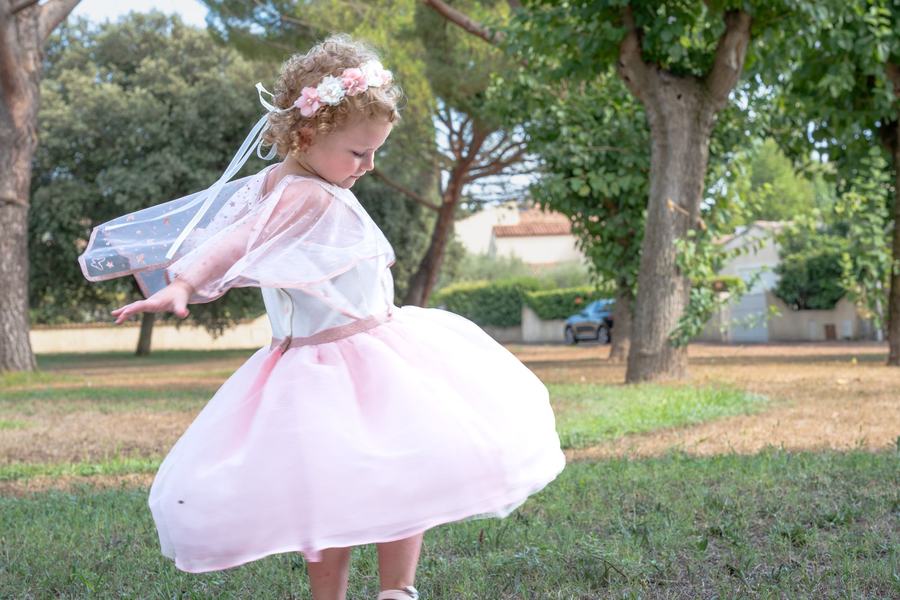Fillette tournoyant dans sa robe de tulle rose