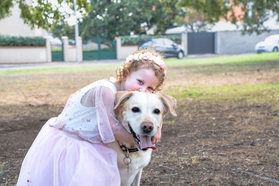 Fillette serrant son chien labrador dans ses bras